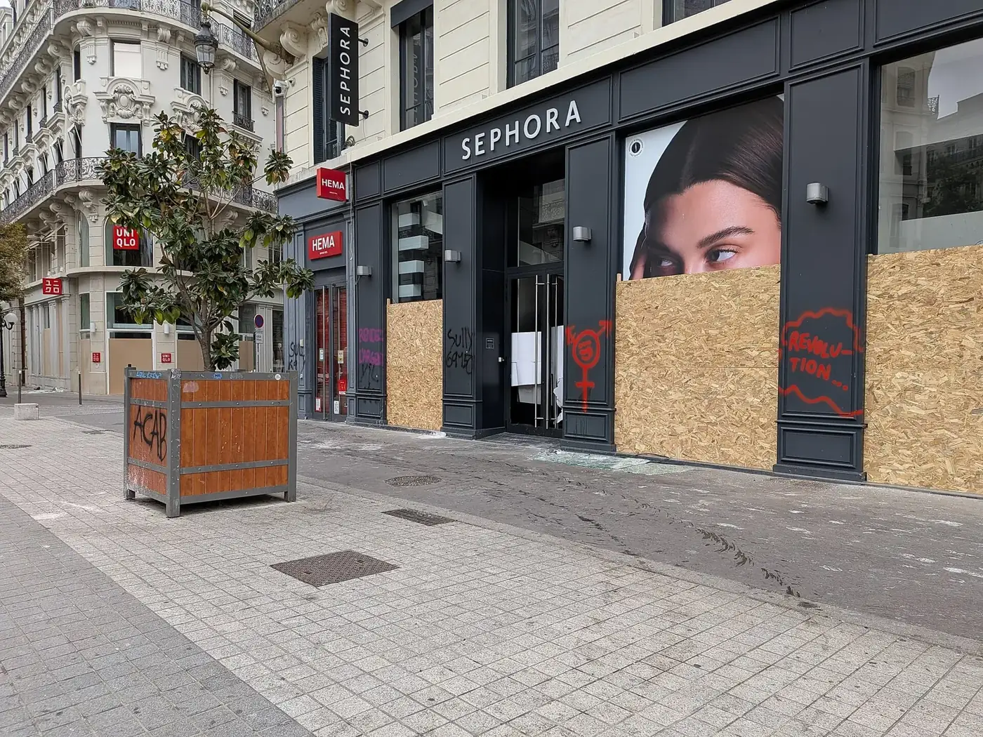 Boarded-up shops on Place de la République in Lyon on 18 October 2026, the day after the protests.