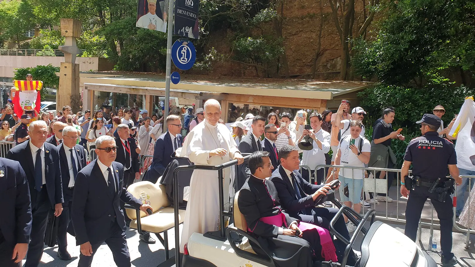 Pope Leo XIV raising his hand to greet pilgrims at the Abbey of Montserrat in Spain